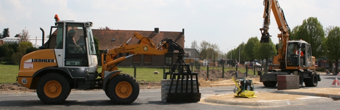 Wiellader en mobiele graafmachine aan het werk bij straatwerk